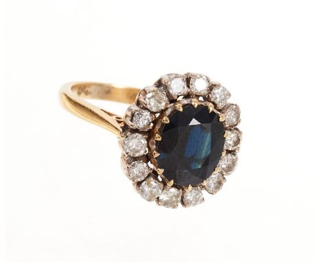 Sapphire and diamond cluster ring, the oval mixed cut blue sapphire measuring approximately 9.1mm x 7.6mm surrounded by a bor