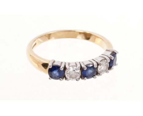 Diamond and sapphire five stone ring with two round brilliant cut diamonds and three round mixed cut blue sapphires in claw s