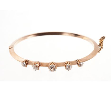 Late Victorian diamond hinged bangle with five old cut diamonds in claw setting on a gold knife edge bar. Estimated total dia
