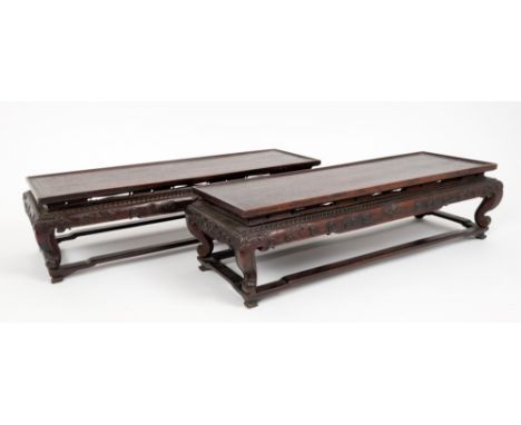 Pair of 19th century Chinese carved hardwood stands, each with dished narrow top and relief scroll carved frieze on scroll br