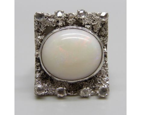A 9ct white gold Brutalist style ring set with eight old cut diamonds and a large opal, Birmingham 1966, 15.6g, 18mm x 21mm