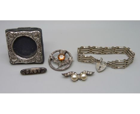A miniature Silver photograph frame, a silver gate bracelet and three silver brooches (faux pearl brooch missing a stone), 25