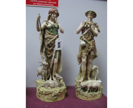 A Pair of Royal Dux Figures of a Shepherd and Shepherdess, she holding a staff with goats at her feet, he playing the pan pip