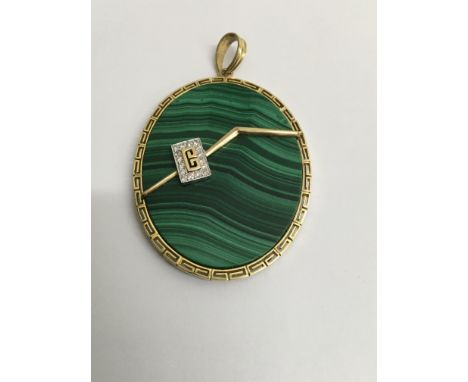 A oval malachite pendant surrounded with a 14 k gold mount .5 cm