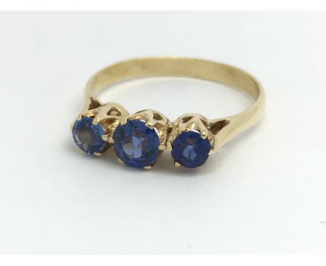 An 18ct yellow gold ring with three blue coloured stones, approx 0.75ct, ring size approx O/P