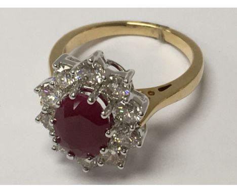 An 18ct yellow gold oval ruby and diamond cluster ring. Ruby 2.25ct. Diamonds 1.50ct