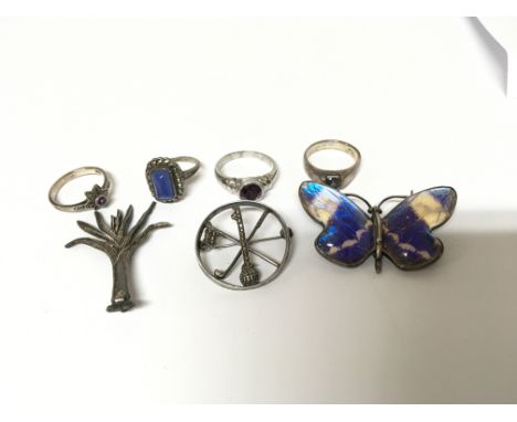 Four silver rings set with amethyst a silver butterfly brooch a vintage silver golfing brooch and one other.