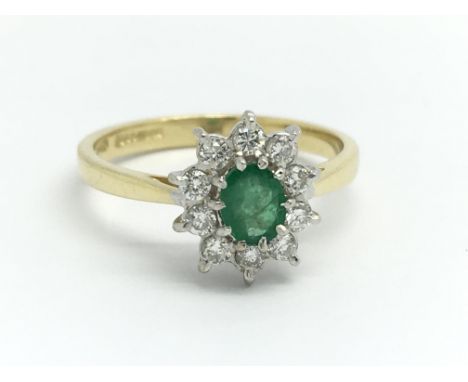 An 18ct yellow gold diamond and emerald cluster ring, size approx N