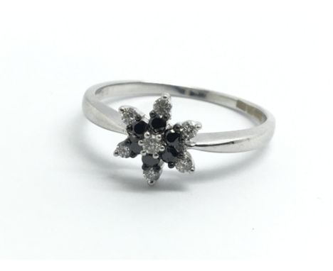 An 18ct white gold, diamond and sapphire cluster ring, approx size O