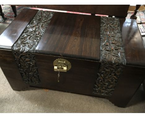 A Quality carved camphor wood Oriental trunk the top and front with two folate carved panels original brass lock with key ver