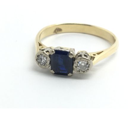 An 18ct yellow gold ring set with central sapphire and two diamonds, approx size P