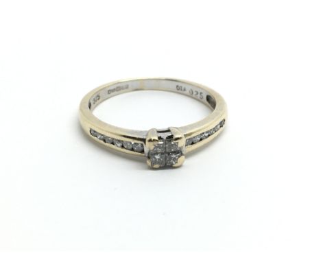 A 9ct yellow gold ring, set with four princess cut diamonds and further diamonds to the shoulders, ring size K/L