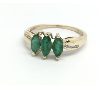 A 9ct yellow gold and three emerald dress ring, approx size R