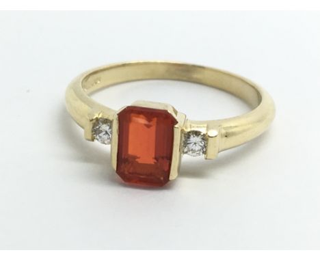 An 18ct yellow gold ring set with fire opal and two diamonds, approx size M