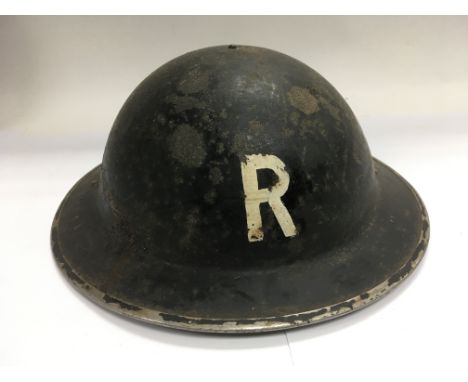 A WW2 era tin hat marked R to the front.