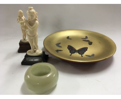 Two small carved ivory figures a full length nude woman and an Indian figure a jade bowl and a lacquered gold Finish dish. (4