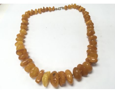 An irregular shaped graduating light amber necklace. Weight 59g