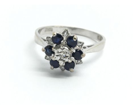 An 18ct white gold, diamond and sapphire cluster ring, size approx K