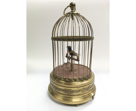An antique singing bird automaton set within a wirework dome top with articulated ring handle, approx total height 28cm.