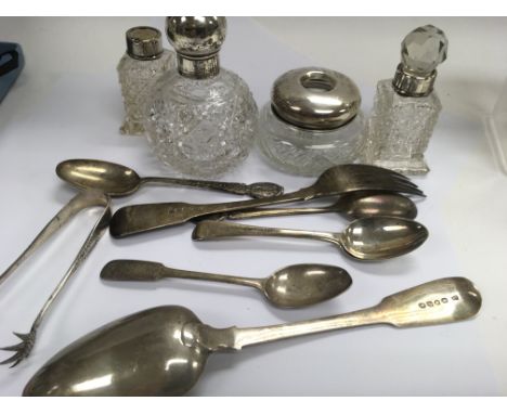 A collection of silver flatware 275 grams glass perfume bottles and a tidy jar .