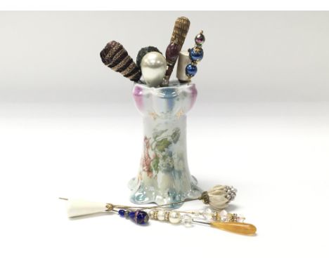 A collection of hat pins in ceramic stand