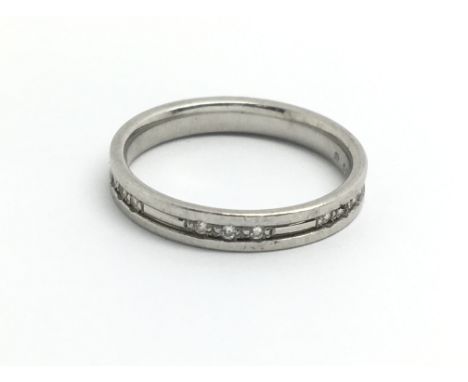 A platinum and diamond ring, the band having three sets of three small diamonds, ring size approx I