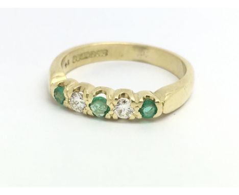 An 18ct yellow gold ring with two diamonds and three emeralds, ring size approx I/J