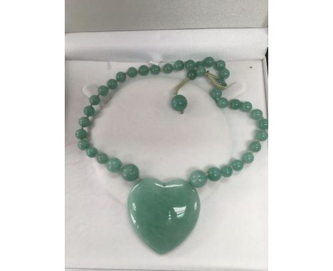A large jade heart shaped pendant.