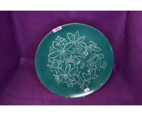 A large Royal Doulton charger having jade green ground with white pattern of ivy,chestnuts and acorns.