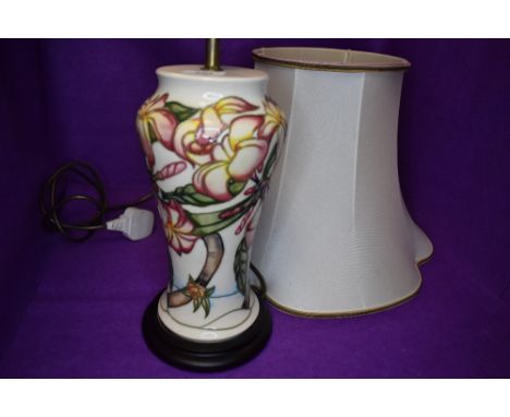 A Moorcroft lamp base having pale pink Magnolia type design on cream ground.