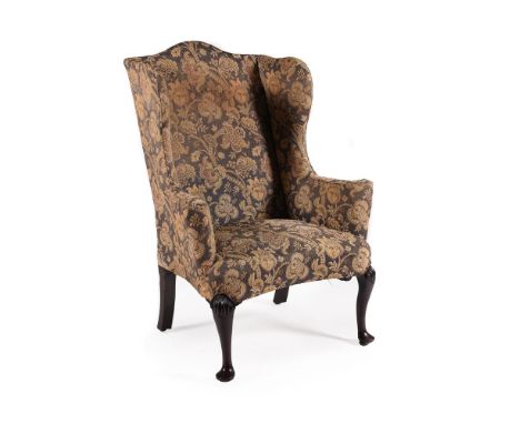 A MAHOGANY AND UPHOLSTERED WING ARMCHAIR IN GEORGE II STYLE, 19TH CENTURYWith oak back legs, all feet with recessed brass cas