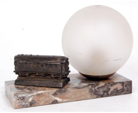 A rare table lamp on marble base, comprising of circular iridescent globe, with white metal model of the Wagon Du Marechel Fo