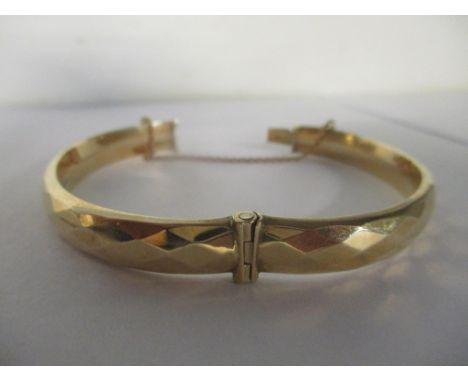 A 9ct gold bangle with safety chain, 10.5gLocation: 