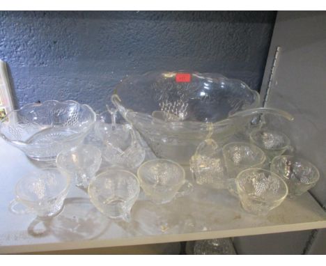 A pressed glass punch bowl with 12 punch cups and a plastic ladle together with a matching pudding bowl all decorated with gr