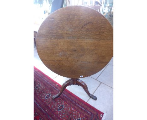 A Georgian oak tilt top table on a tripod base, 67cm tall, 82cm in diameter 