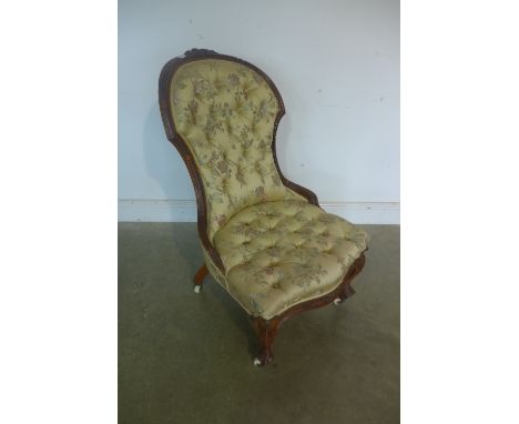 A Victorian walnut button back fireside chair 