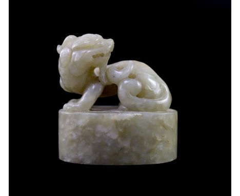 A Chinese celadon and white mottled jade ‘lion-dog’ seal, 18th/19th century,the beast sitting upon an oval base,6cm longTypic