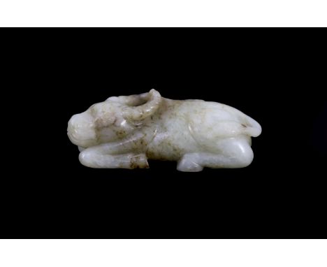 A Chinese Ming pale celadon and brown jade figure of a recumbent Buffalo, 16th/17th century,with details of the cord tied to 