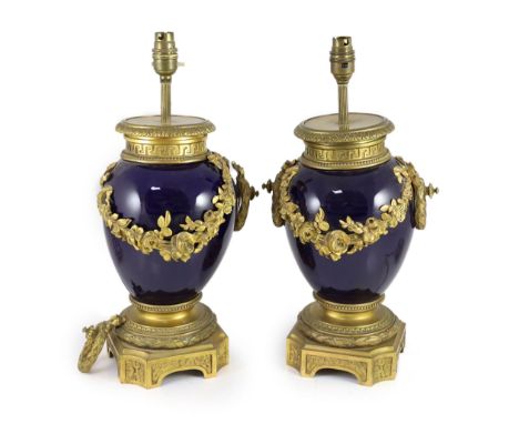 A pair of Louis XVI style ormolu mounted bleu du roi porcelain table lamps,with floral swag decoration,width 23cm height 40cm
