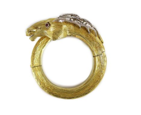 A 20th century Continental textured 14k gold, ruby and diamond set hinged bangle, modelled as the head and tail of a horse,in