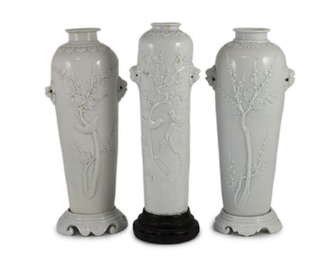 A near pair of Chinese blanc-de-chine sleeve vases with stands and a similar slender vase, Dehua kilns, 18th centuryeach reli