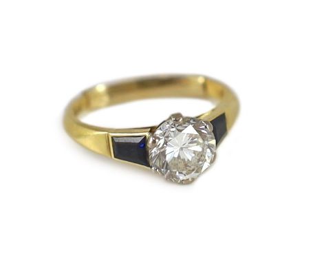 A modern 18ct gold and single stone diamond ring, with trapeze cut sapphire set shoulders,the diamond weighing approximately 