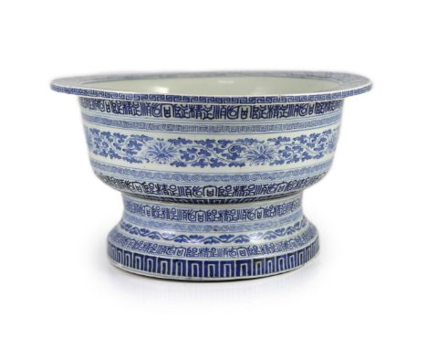 A unusual Chinese blue and white pedestal bowl or basin, 19th century,painted with scrolling foliage and bands of repeating c