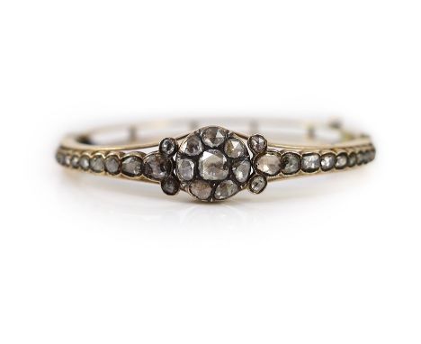 A Victorian style gold and rose cut diamond cluster set hinged bangle, with graduated rose cut diamond set shoulders,interior