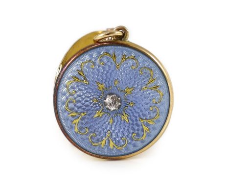 An Edwardian engine turned gold, blue guilloche enamel with gilded scrolls and diamond set circular pendant locket,with safet