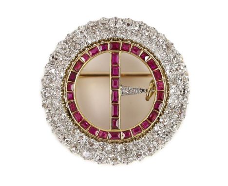 A 20th century gold and platinum, ruby and diamond set openwork circular 'buckle' brooch,with safety chain and set with two c