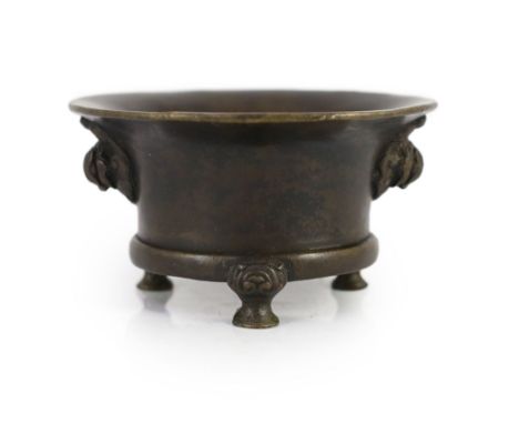 A Chinese bronze tripod censer, 18th century,cast with a pair of mythical beast mask handles, on three shaped feet headed by 