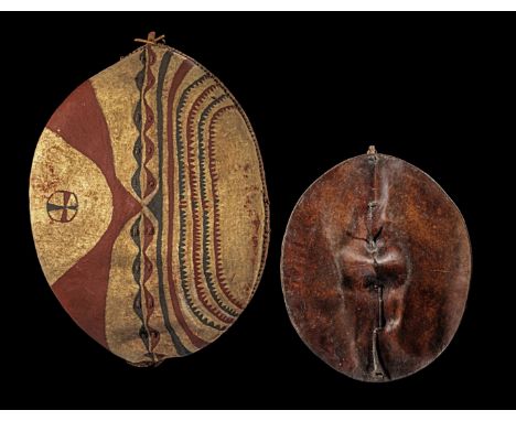 Zwei Rundschilde. Massai, Kenia / Tansania &amp; Irangi, Tansania. Beide Leder bzw. Haut. Das Massai-Schild (L 98cm) mit hölz
