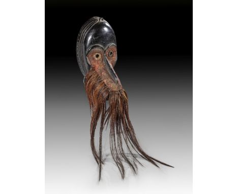 Schnabelmaske 'gägon'. Dan / Diomande, Liberia. H 24cm. Holz, Metall, Tierhaare, Stoff, aus schwarz gefärbtem Holz mit runden