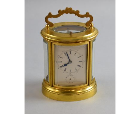 Early 20th century brass and  glass oval carriage clock with repeat and alarm striking on bell  18cm       